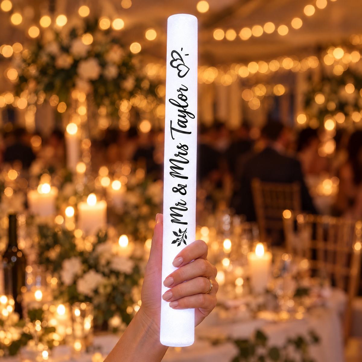 Hand holding a personalised white LED glow stick printed Mr &amp; Mrs Taylor, 35 cm long